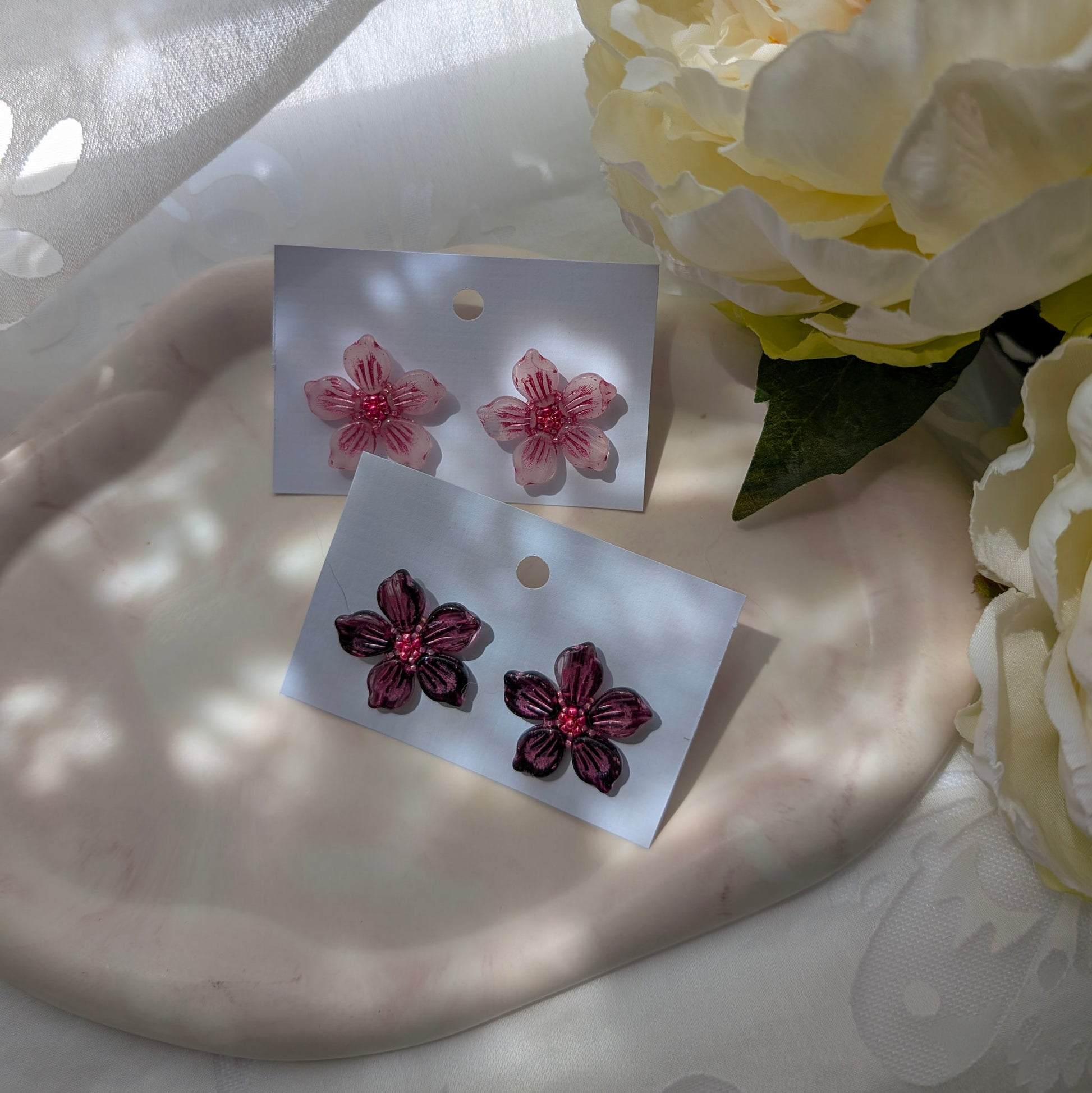 Floral earrings on display with a soft background.
