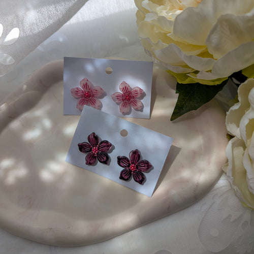 Floral earrings on display with a soft background.
